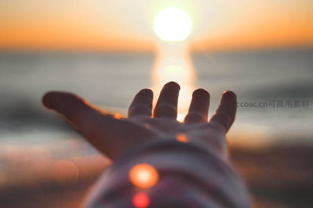 日落时分伸手触摸海平线上的太阳