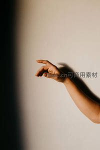 阳光下的优雅手势，墙面上投下清晰剪影