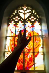 教堂彩窗前的祈祷之手，神圣光芒洒落