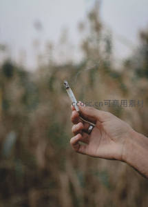 手持香烟轻吐烟圈，背景朦胧如梦