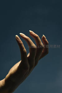 深蓝背景下光影交织的手指特写