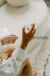 女子手中轻握一瓶香水瓶
