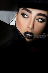 暗影中的神秘妆容，黑唇与锐利眼神