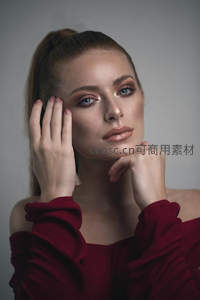 红衣女子轻抚脸颊，温柔眼神迷人