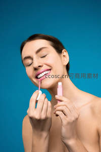 女子微笑涂抹唇彩，享受美妆时刻