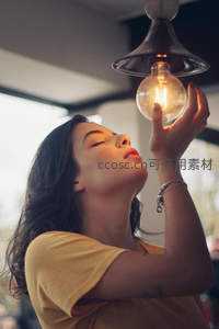 仰望灯泡的女子，温暖光芒照亮梦想