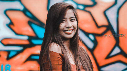 街头涂鸦前微笑的年轻女子