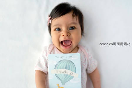 三个月宝宝举牌开心吐舌头