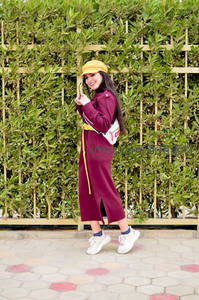 时尚女孩在绿篱前摆拍街拍