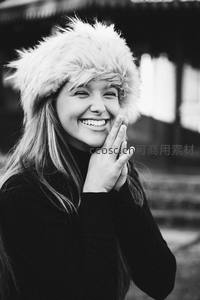 黑白影像中戴毛帽少女捂嘴俏皮微笑