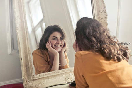 卷发女子对镜微笑享受晨间时光