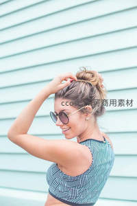 时尚女郎整理发髻，墨镜遮阳尽显都市风情
