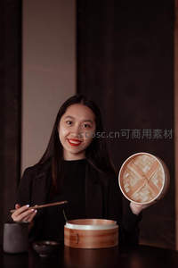 优雅女子展示竹制蒸笼美食