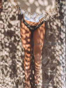 躺着沙滩上的比基尼性感女孩，健康肤色修长美腿