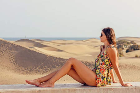 沙漠边缘女子远眺蔚蓝大海