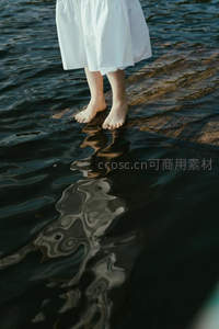 白裙少女赤足立于水波之上的倒影