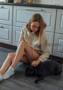 厨房地板上温柔抚摸宠物的少女