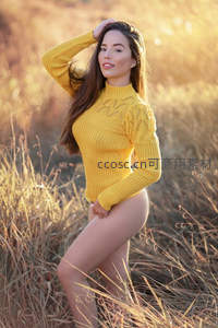 金秋草地上穿黄毛衣的女子