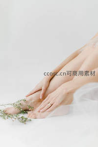 纯白背景下温柔抚触足踝的瞬间