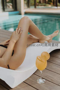 躺椅上放松的女子与橙色鸡尾酒