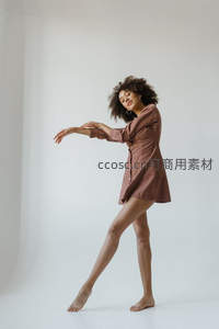 卷发女子优雅舞动于纯白空间