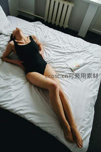 黑衣女子舒展躺卧床上休憩