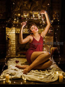 壁炉旁，女子与暖光灯串共度温馨圣诞夜