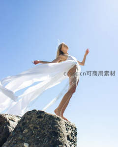 白衣飘逸立礁石，迎风舒展如仙子