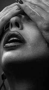 黑白光影中手遮面庞的性感唇部特写
