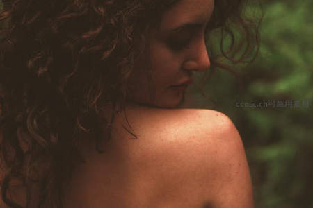 卷发女子侧颜凝视自然背景