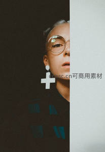 戴眼镜女性侧颜，十字耳环点缀