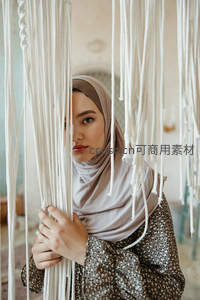 穆斯林女性透过编织帘幕凝视镜头