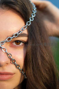 金属链条轻绕眉眼，自然光下的时尚特写
