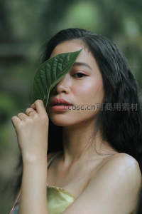 绿叶遮面的自然少女