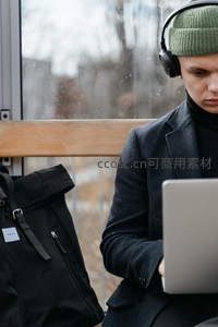 男子戴耳机专注使用笔记本电脑