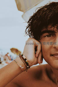 沙滩青年手托脸颊微笑