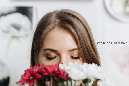 闭目嗅花的少女，红白花瓣映面