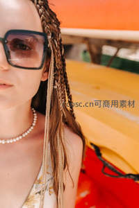 编发墨镜女郎，彩色皮艇旁度假风