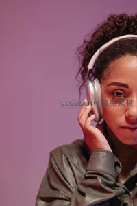 卷发女子戴耳机沉浸音乐世界