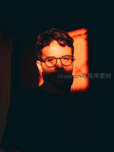 暖光下戴眼镜男子深邃眼神特写