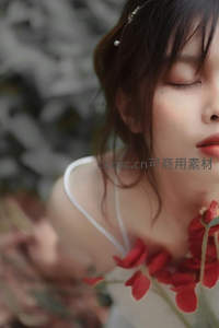 闭目女子手持红玫瑰花束