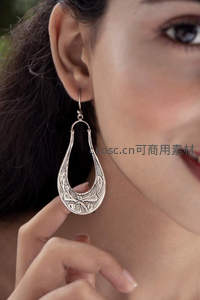 精致银饰耳环特写，展现细腻雕花工艺