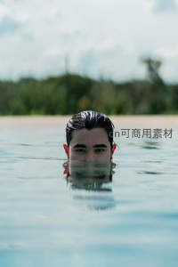 男子水中仰望，水面倒影如镜