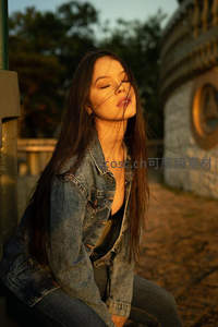 夕阳下闭目享受微风的少女