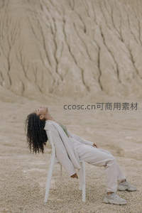 荒漠中女子仰躺白椅享受宁静