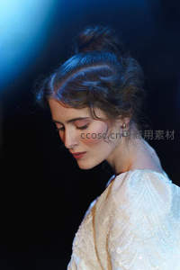 蓝光下的优雅侧颜，发髻与珍珠耳饰的温柔邂逅