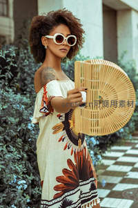 非洲印花裙配竹扇，街头时尚与自然绿植的完美融合