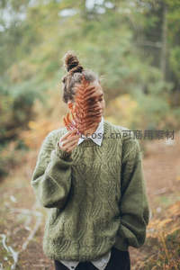 森林中女子手持枫叶遮面