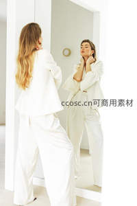 白衣女子镜前整理仪容姿态优雅