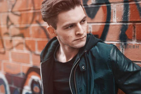 街头青年倚靠涂鸦墙展现潮流风范